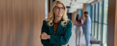 Confident business woman standing in modern office hallway
