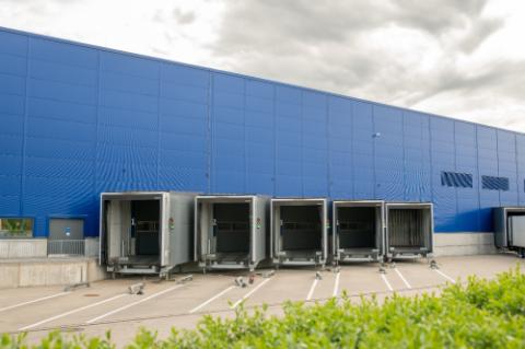 industrial waste containers near modern warehouse building exterior