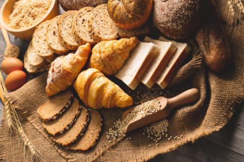 Different kinds of bread with nutrition whole grains on wooden background. Food and bakery in kitchen concept. Delicious breakfast gouemet and meal. Top view angle