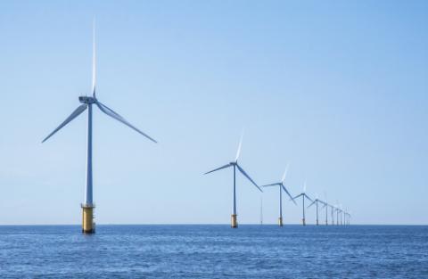Wind turbines in an offshore wind farm in the North Sea just off the coast of the Netherlands, on a clear day.
