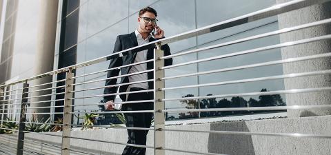 Entrepreneur walking outdoors talking on mobile phone