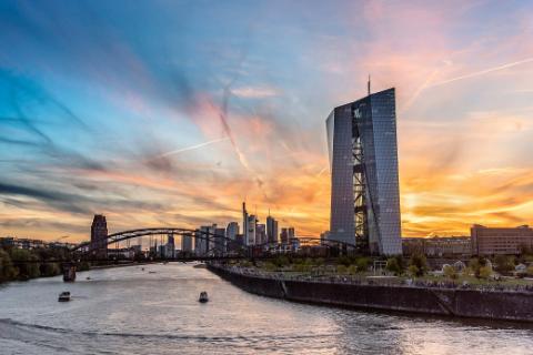 Europäische Zentralbank mit Skyline im Abendlicht