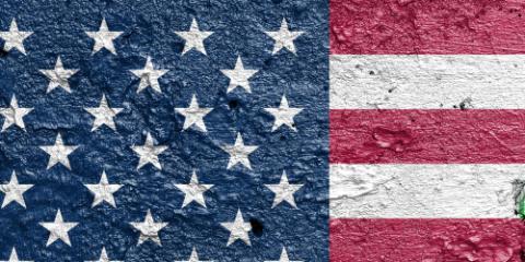 United States of America vs Iran - Cracked concrete wall painted with a USA flag on the left and a Iranian flag on the right stock photo