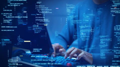 A developer types on a computer with glowing code and binary symbols overlay, symbolizing programming, software development, cybersecurity, and digital technology.