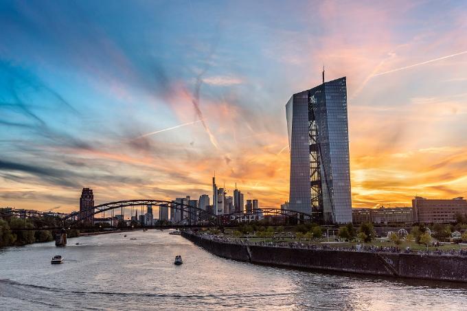 Europäische Zentralbank mit Skyline im Abendlicht