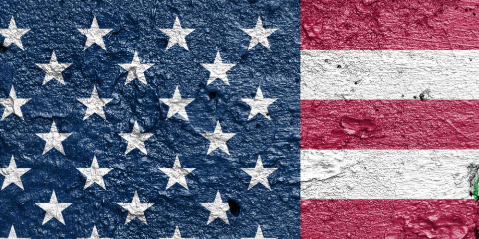 United States of America vs Iran - Cracked concrete wall painted with a USA flag on the left and a Iranian flag on the right stock photo