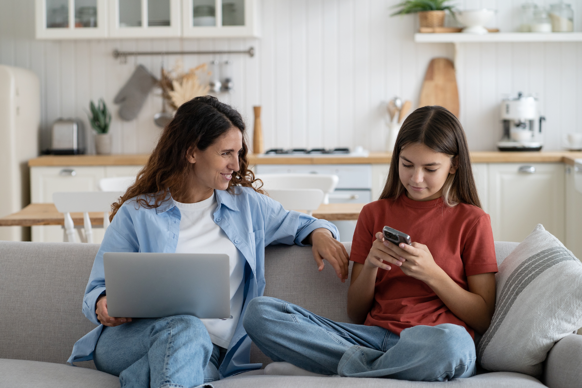 Young smiling modern mother talking to child daughter about online safety