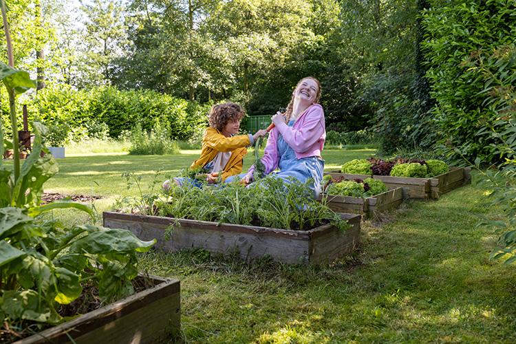 moeder met kind in moestuin