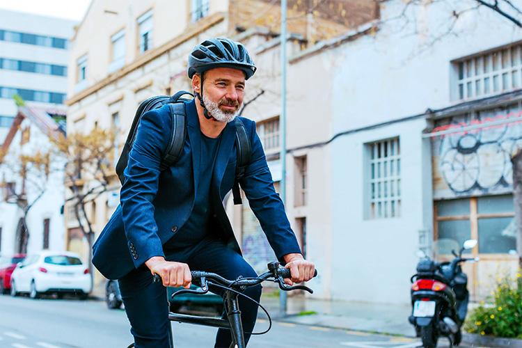 man met fietshelm op fiets