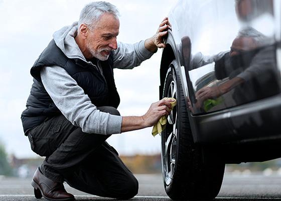 Man poetst zijn auto en zorgt voor onderhoud