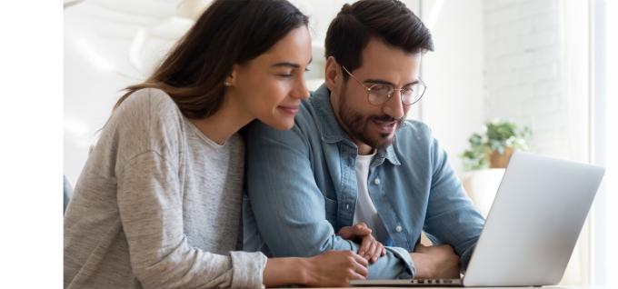 Inspiring image of a young couple using a laptop on page about putting a security deposit on a blocked account