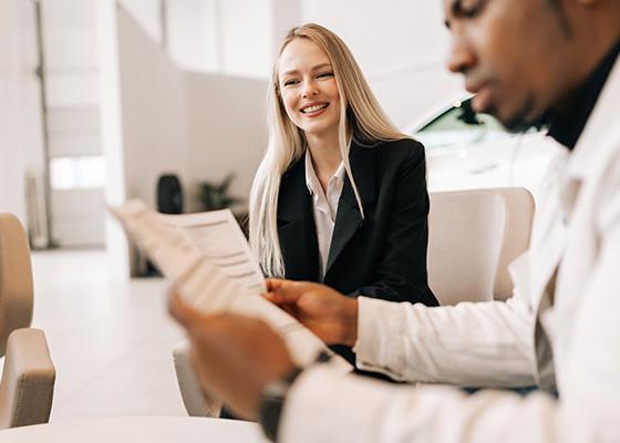 Vrouw regelt de administratie van haar nieuwe auto samen met een adviseur