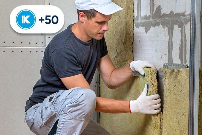 Un homme pose de l'isolant sous la toiture