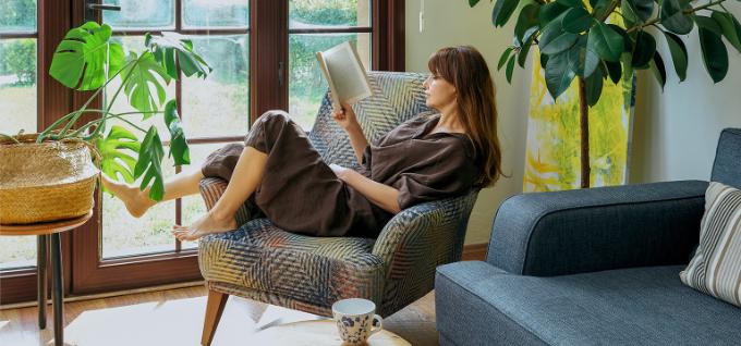 vrouw leest een boek aan haar raam