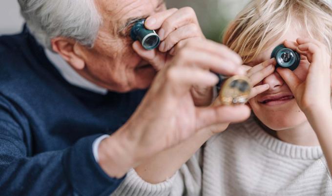 Grootvader kijkt met kleinzoon naar munten