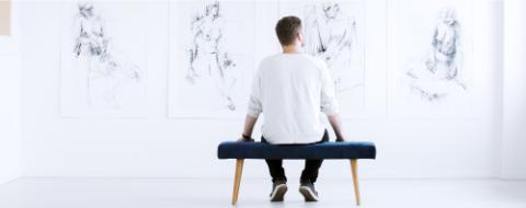 Man looking at charcoal drawings