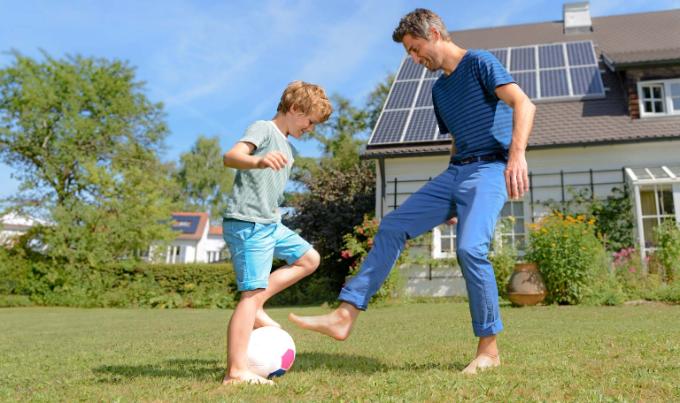 Vader en zoon voetballen voor huis met zonnepanelen op het dak. Zijn ze verzekerd?